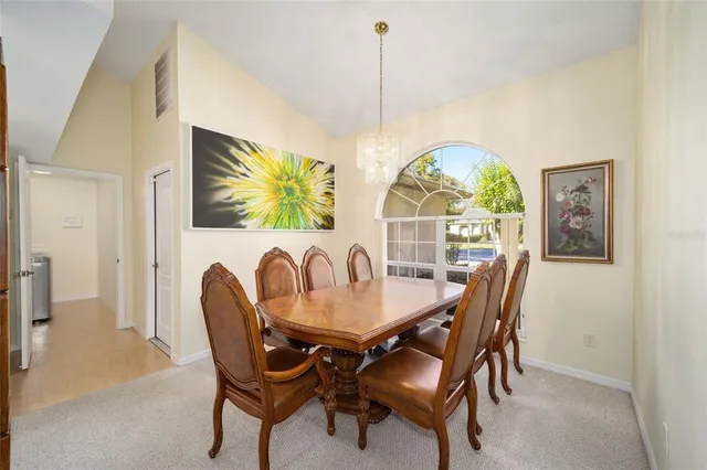 a view of a dining room with furniture and a chandelier