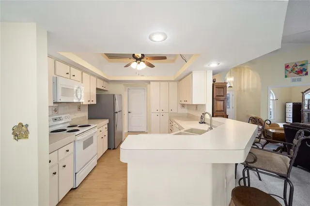 a kitchen with kitchen island a stove a sink and cabinets