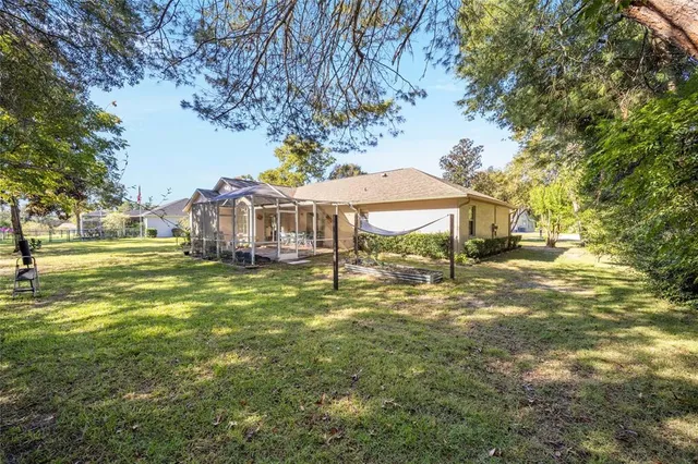 a small pool with lawn chairs under an umbrella