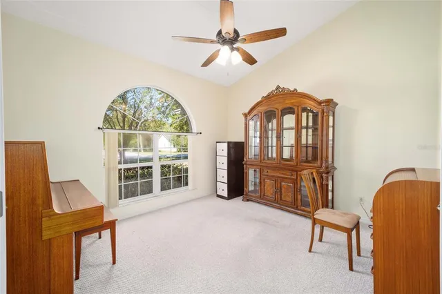 a living room with furniture a ceiling fan and a window