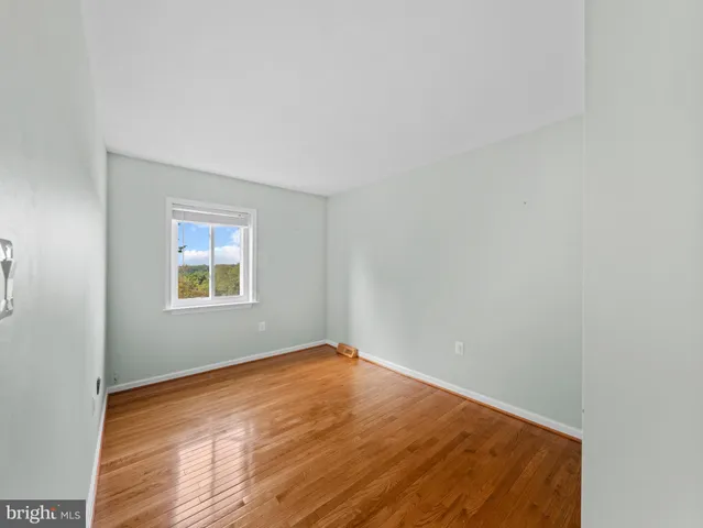 a view of a room with wooden floor and white walls