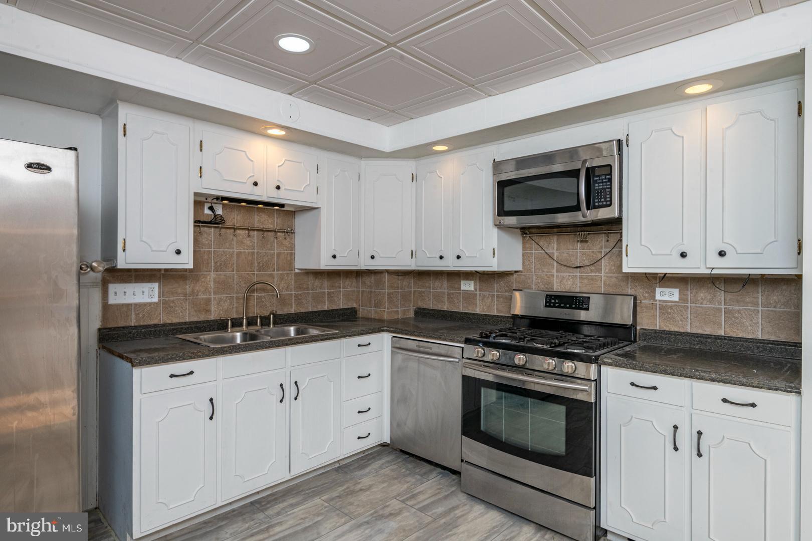 202 Water Street Oley, PA 19547 - Photo 11 of 30 a kitchen with stainless steel appliances granite countertop a stove a sink and a microwave