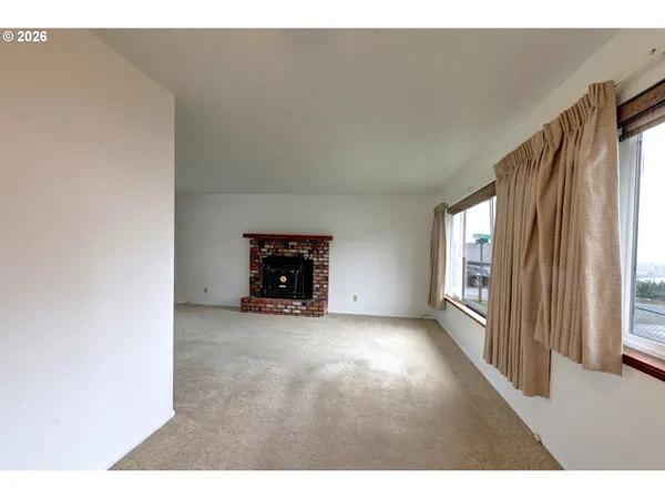a view of a livingroom with wooden floor and a fireplace