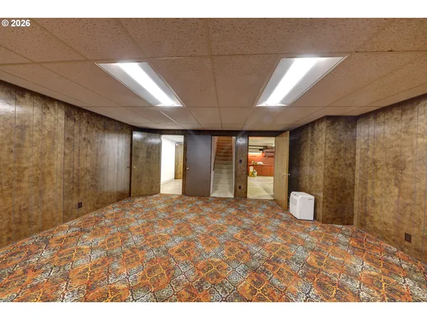 a view of an empty room with window and cabinet