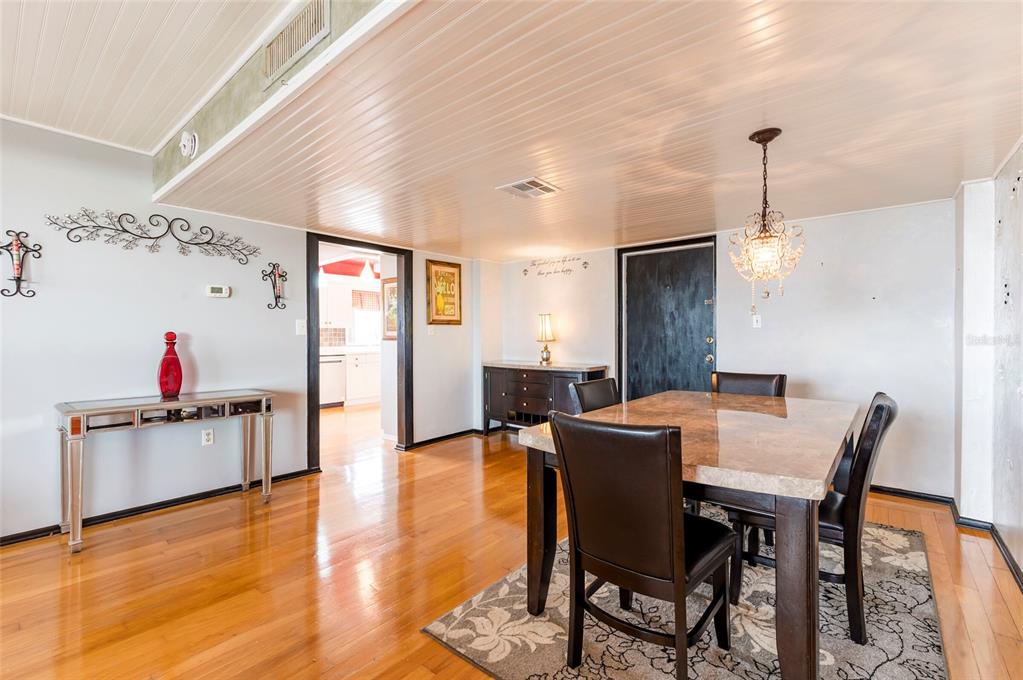 9 Haig Place, Unit 801 Dunedin, FL 34698 - Photo 12 of 36 a view of a dining room with furniture and wooden floor