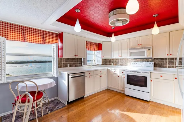 a kitchen with stainless steel appliances granite countertop a stove cabinets and wooden floor