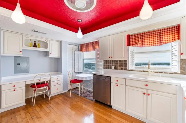 a kitchen that has a lot of cabinets a sink and appliances in it