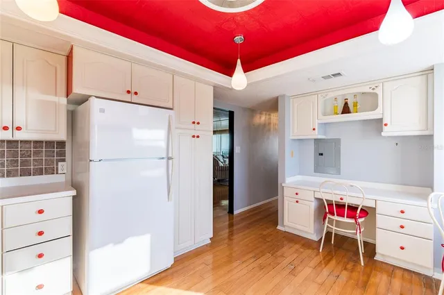 a kitchen with a refrigerator and wooden floor