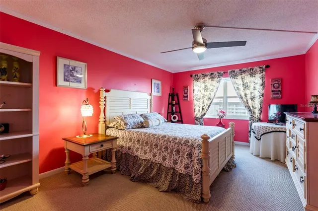 a bedroom with a bed and large windows