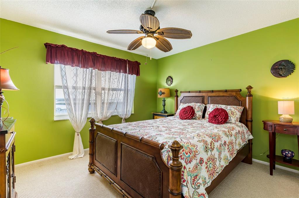 9 Haig Place, Unit 801 Dunedin, FL 34698 - Photo 30 of 36 a bedroom with a bed and a chandelier