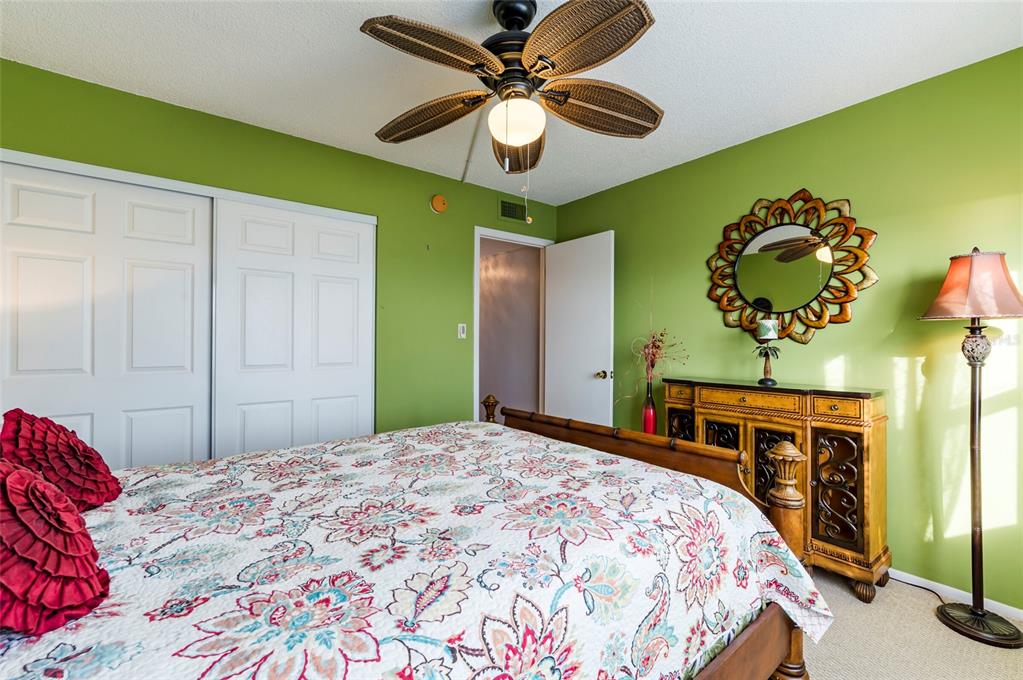 9 Haig Place, Unit 801 Dunedin, FL 34698 - Photo 32 of 36 a bedroom with a bed and a chandelier