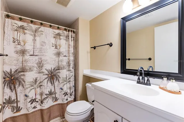 a bathroom with a sink a toilet and shower curtain