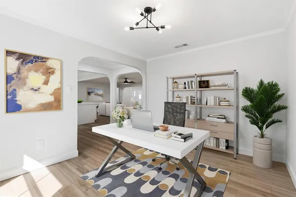 a living room with furniture a potted plant and open kitchen view