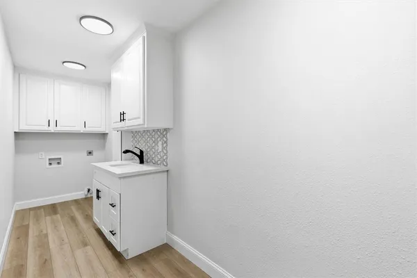 a view of a kitchen with white cabinets and wooden floor