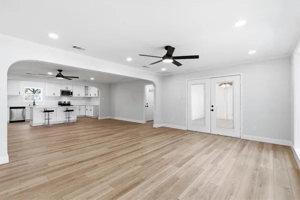 a view of empty room with wooden floor and window