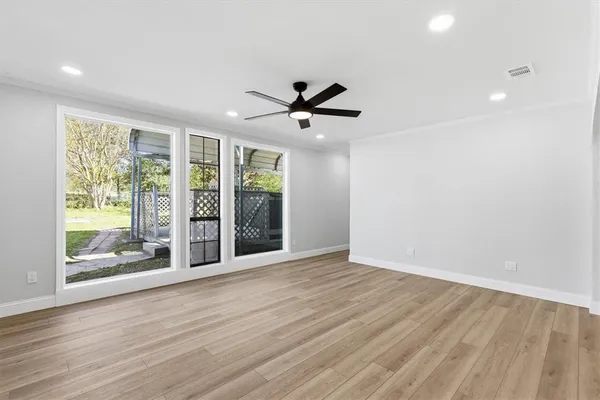 a view of n empty room with window and wooden floor