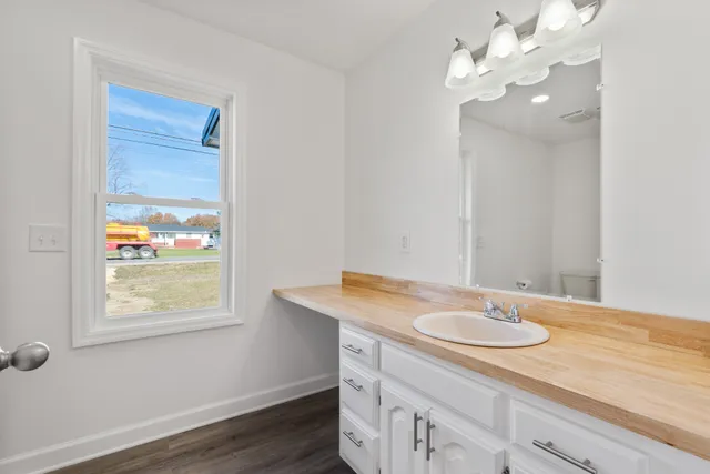 an empty room with wooden floor ceiling fan and windows