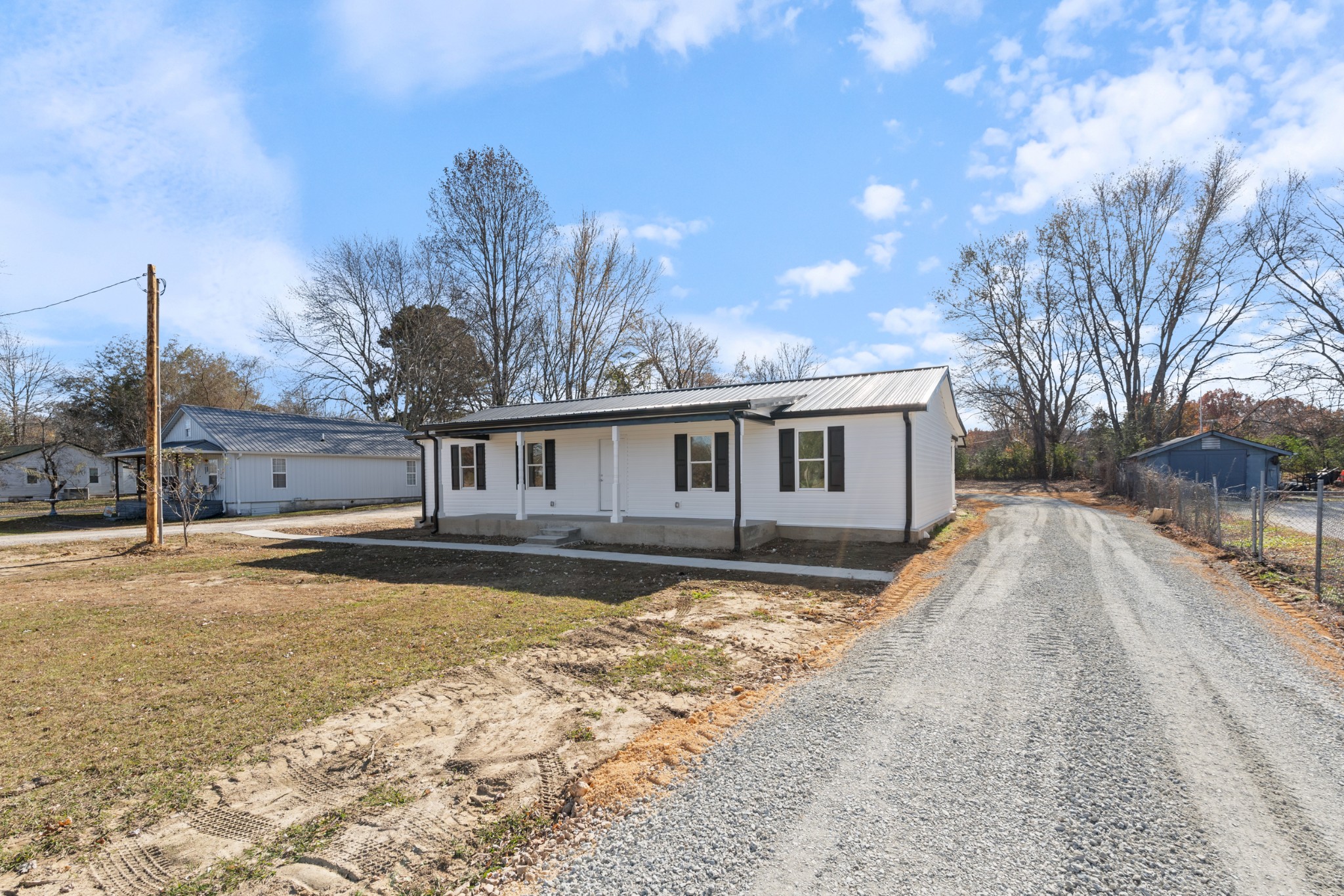 654 West Main Street Hohenwald, TN 38462 - Photo 2 of 33 a front view of a house with a yard and trees