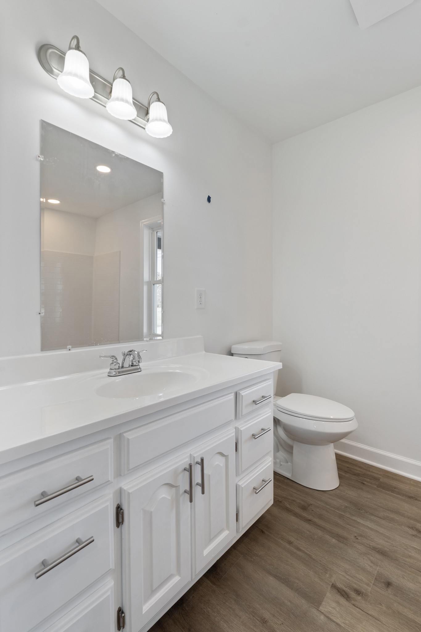 654 West Main Street Hohenwald, TN 38462 - Photo 23 of 33 a bathroom with a toilet a sink and mirror