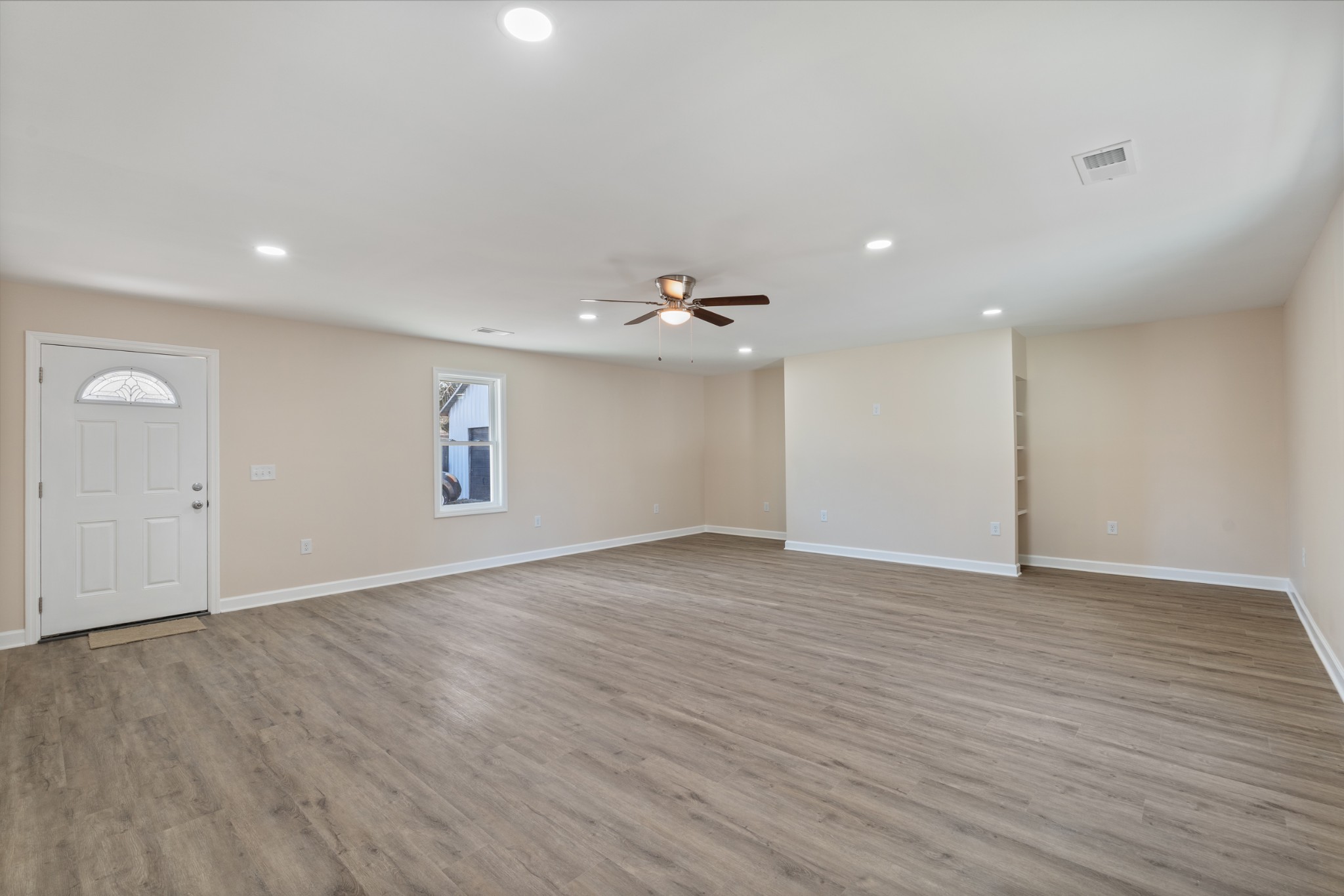654 West Main Street Hohenwald, TN 38462 - Photo 24 of 33 an empty room with wooden floor and windows