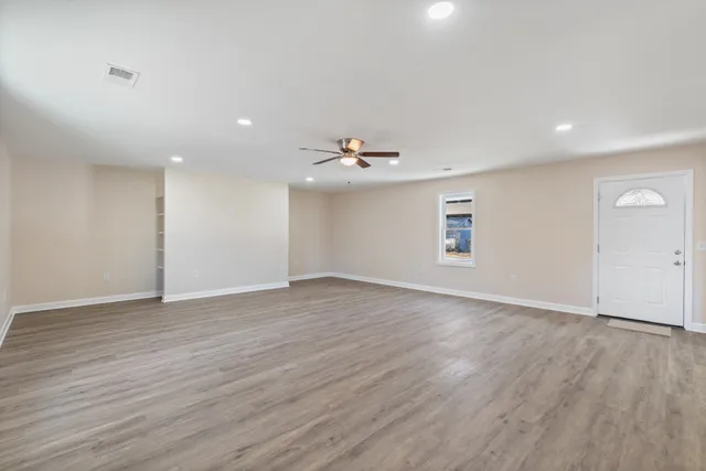 wooden floor in an empty room with a window