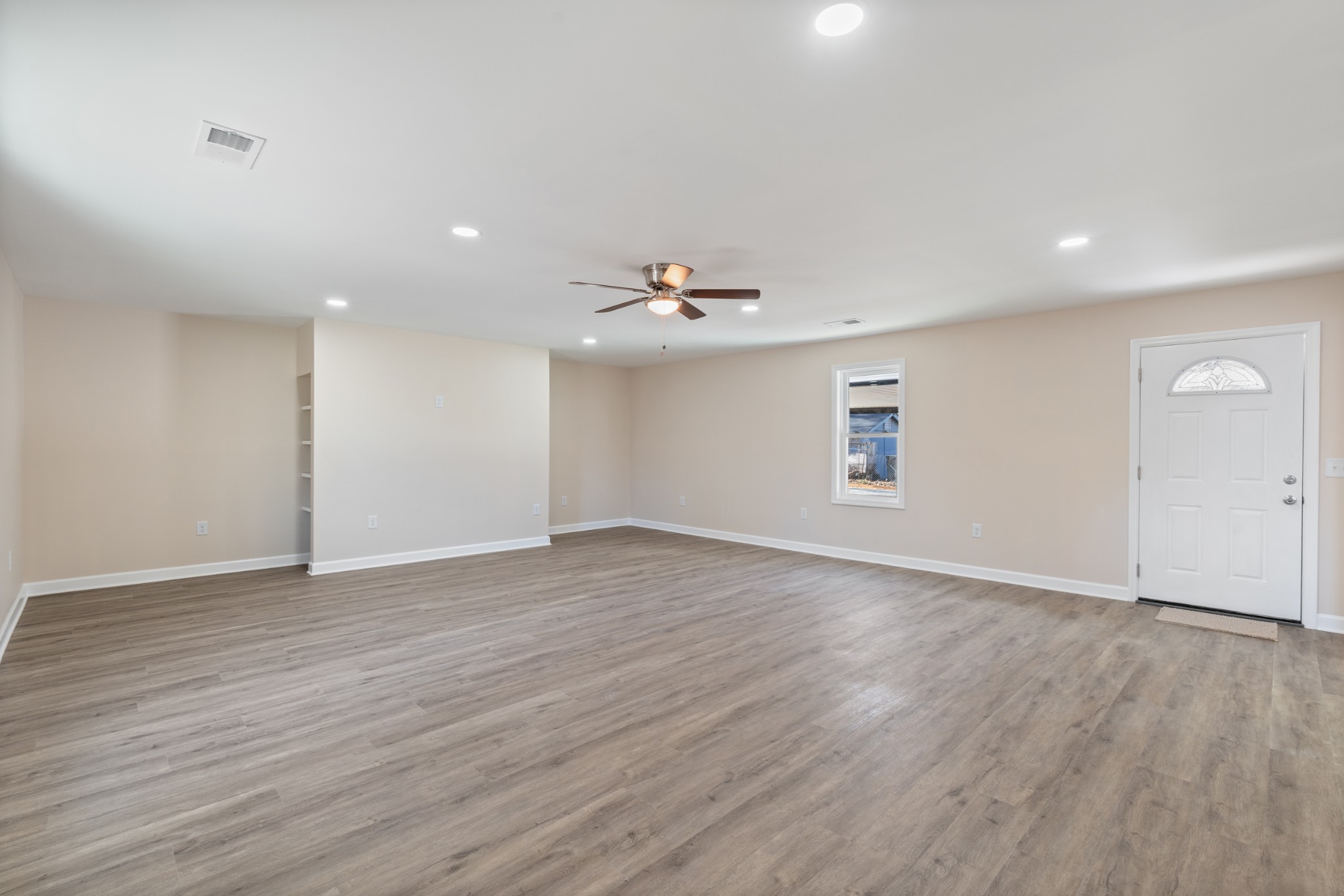 654 West Main Street Hohenwald, TN 38462 - Photo 25 of 33 a view of an empty room with wooden floor and a window