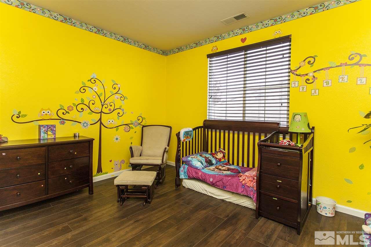 570 Needles Court Reno, NV 89521 - Photo 15 of 18 a bedroom with a bed and wooden floor
