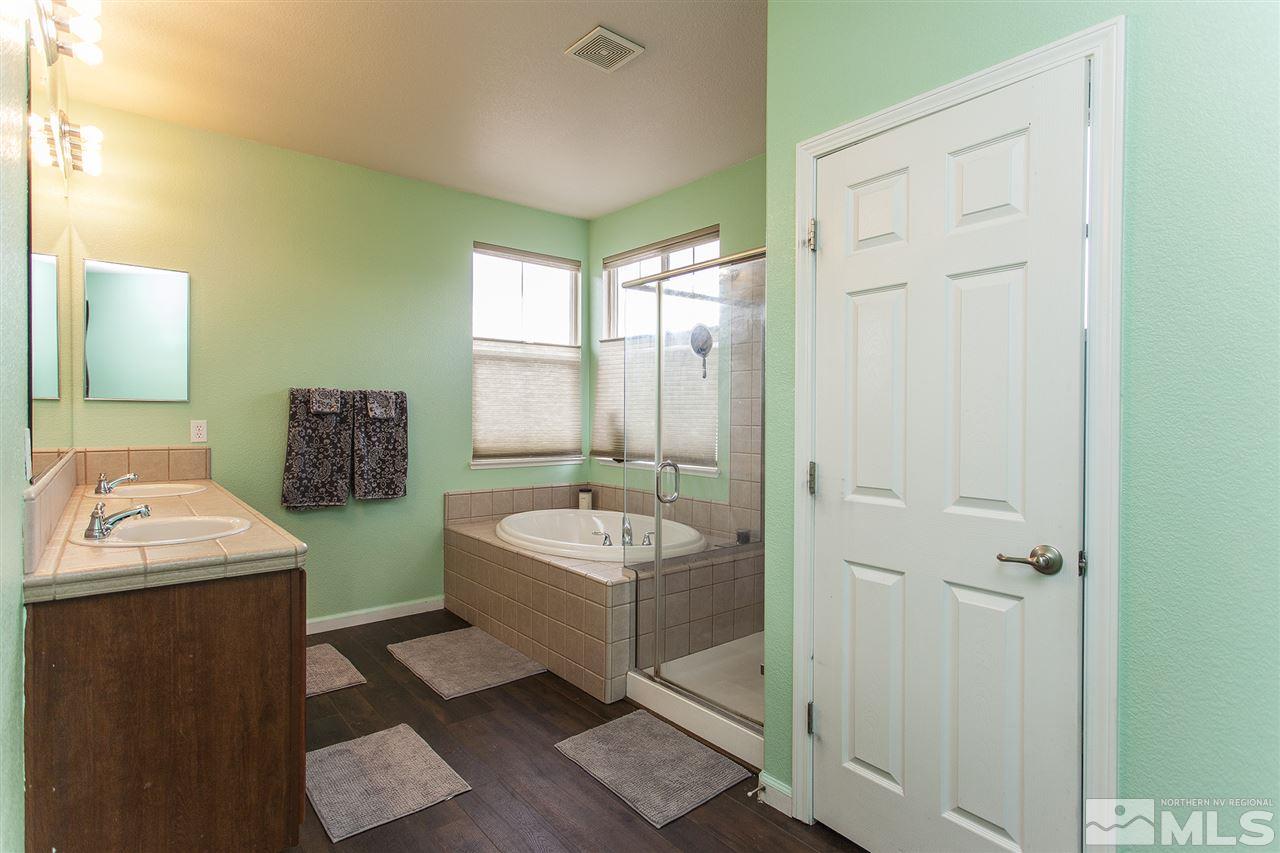 570 Needles Court Reno, NV 89521 - Photo 16 of 18 a spacious bathroom with a double vanity sink a mirror and a bathtub