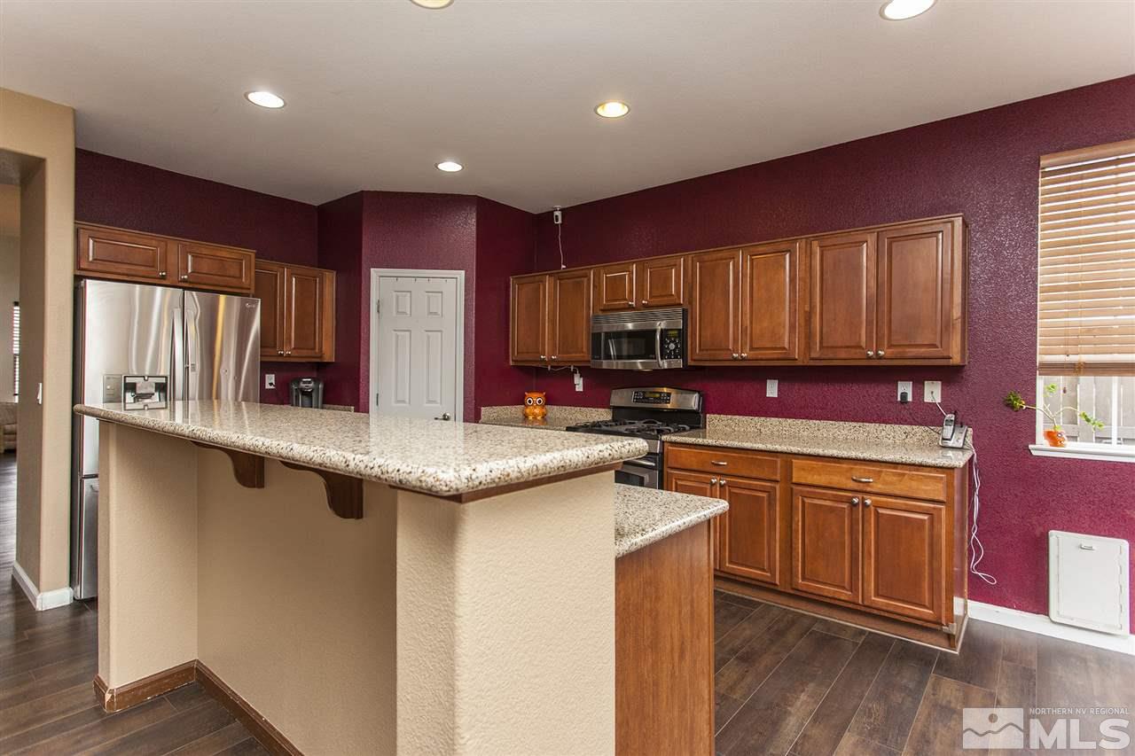 570 Needles Court Reno, NV 89521 - Photo 5 of 18 a kitchen with stainless steel appliances granite countertop a sink stove cabinets and wooden floor