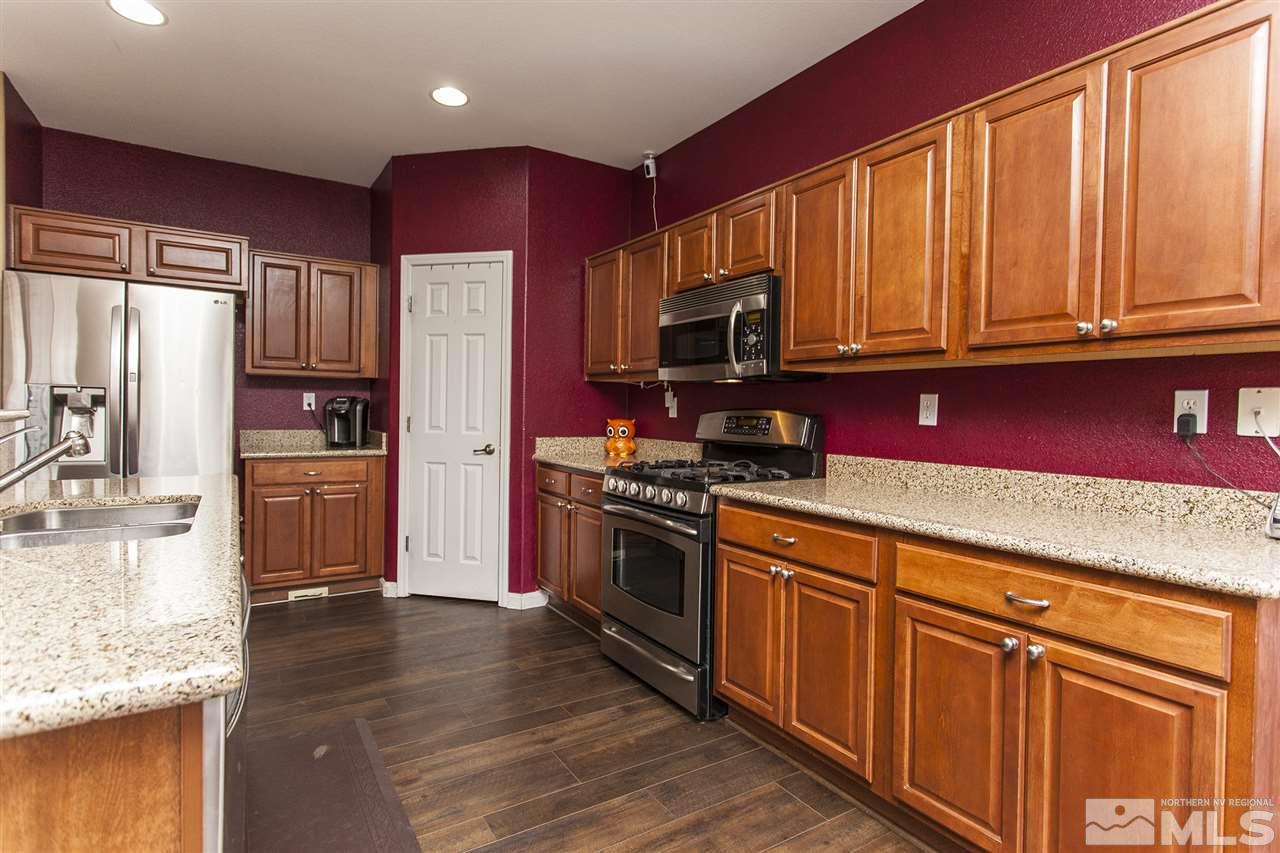 570 Needles Court Reno, NV 89521 - Photo 6 of 18 a kitchen with stainless steel appliances granite countertop a refrigerator stove top oven and sink