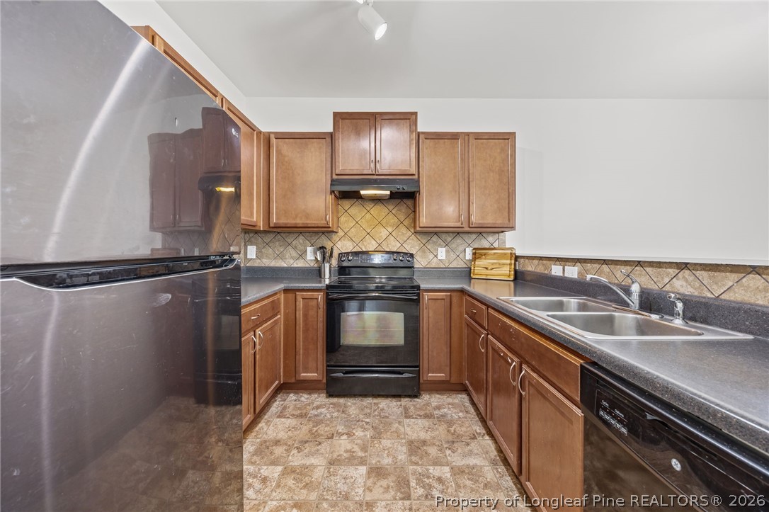 226 River Oak Street Spring Lake, NC 28390 - Photo 16 of 41 a kitchen with granite countertop a sink stove and refrigerator