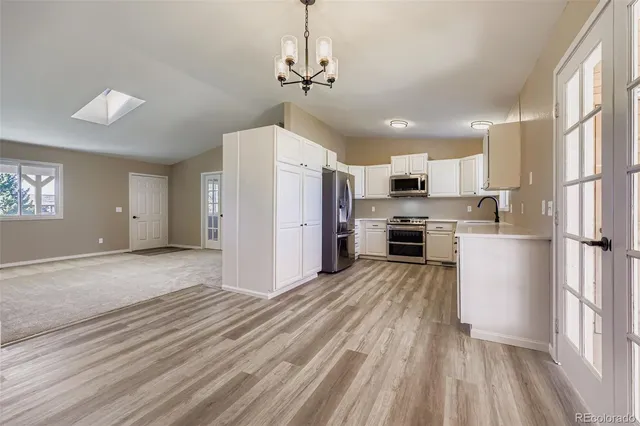 a kitchen with granite countertop a refrigerator and a stove top oven
