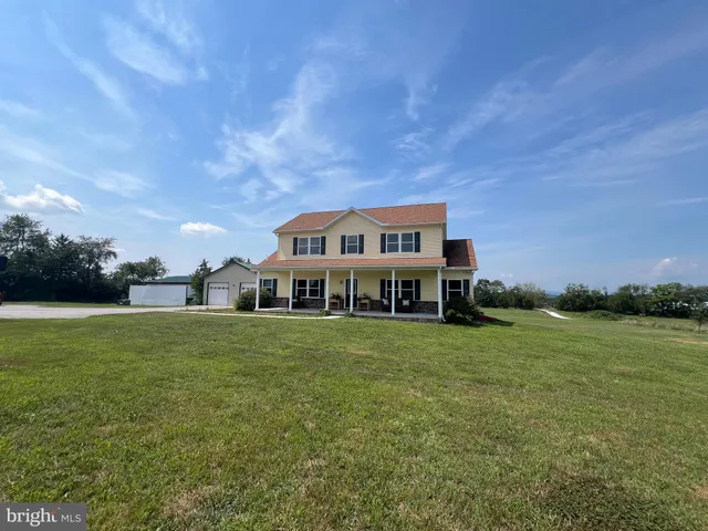 a view of a big house with a big yard and large trees