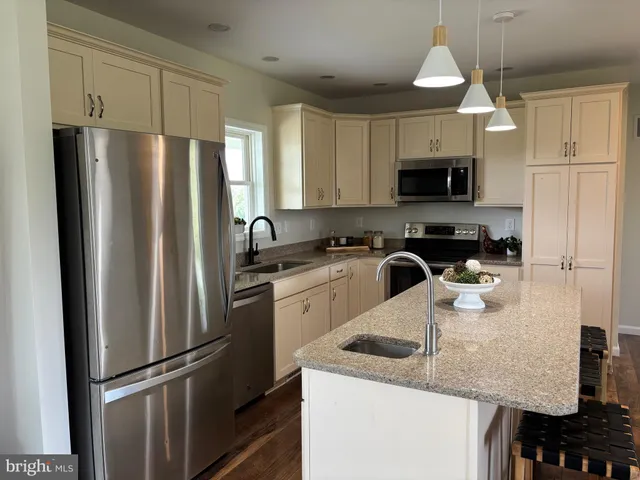 a dining room with wooden floor a chandelier a wooden table and chairs