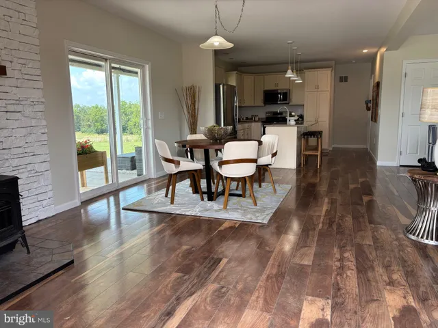 a kitchen with a dining table chairs and refrigerator