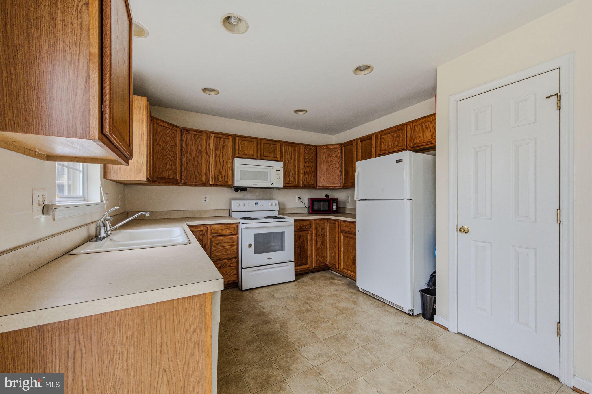 99 Jack's Way Camden, DE 19934 - Photo 14 of 30 a kitchen with a refrigerator a stove top oven a sink and cabinets