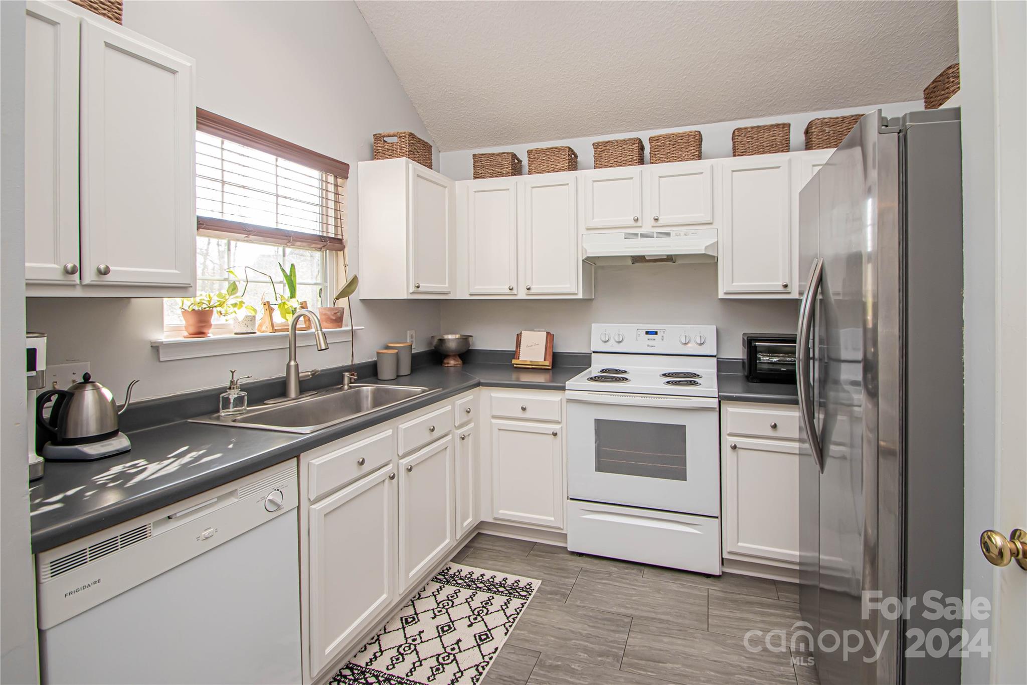 10135 Faires Farm Road Charlotte, NC 28213 - Photo 10 of 31 a kitchen with white cabinets and white appliances