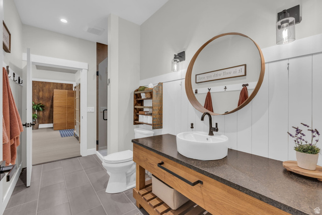1766 West Tollgate Cyn Road Coalville, UT 84017 - Photo 11 of 59 Modern vanity featuring a vessel sink, dark countertop, and wood-finish cabinetry