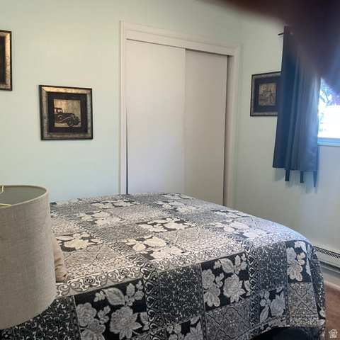 98 Main Street Manila, UT 84046 - Photo 22 of 36 Bedroom featuring a sliding closet door, light-toned walls, and a window with dark curtains
