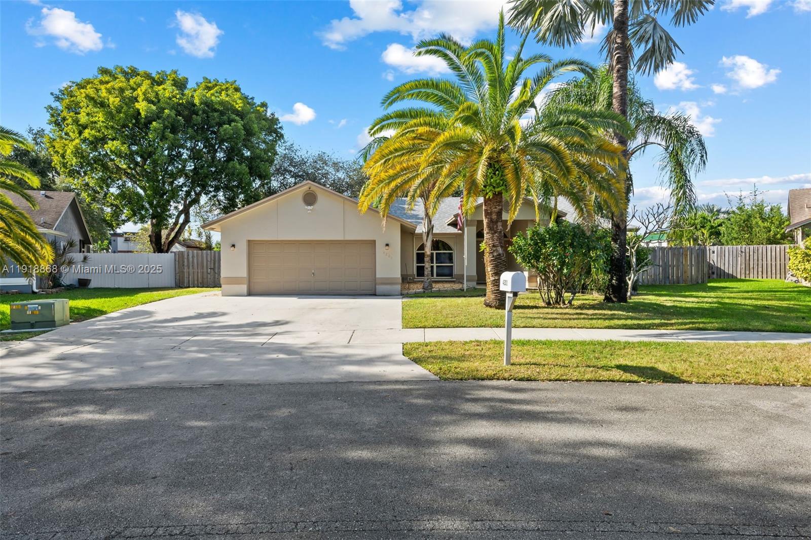 a view of a house with a big yard and palm trees