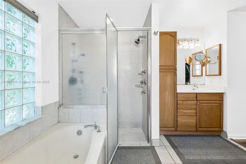 a bathroom with a tub sink shower and mirror