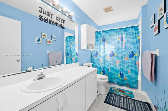 a bathroom with a sink a toilet and shower curtain