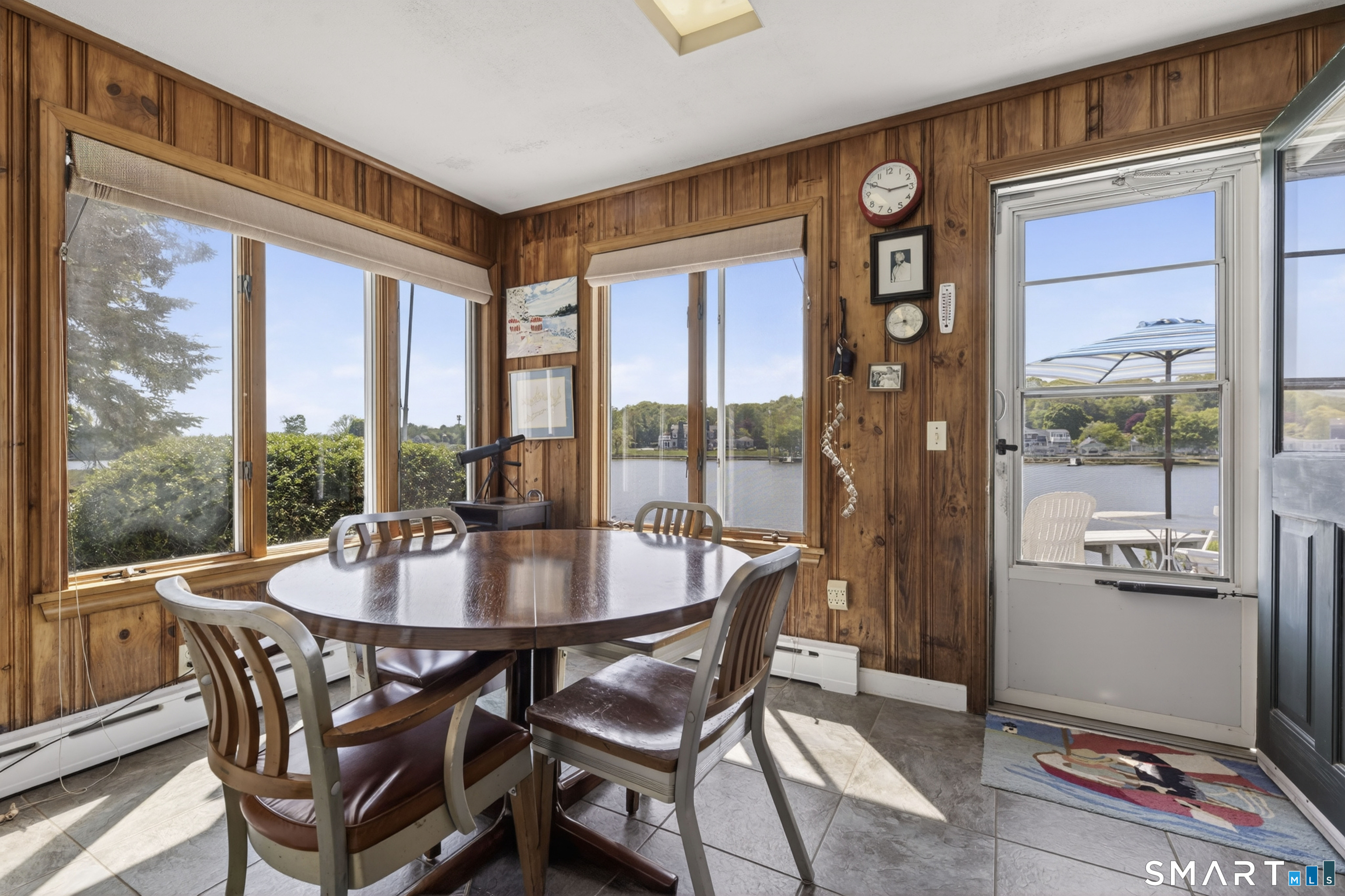 27 Wilbur Road Stonington, CT 06378 - Photo 23 of 40 a dining room with furniture large windows and wooden floor
