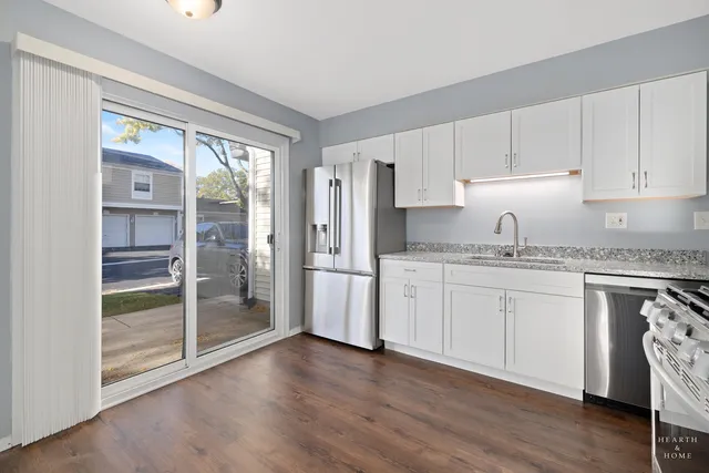 a kitchen with granite countertop a refrigerator sink and cabinets