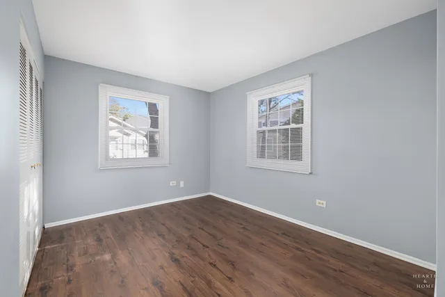 a view of a big room with wooden floor and windows