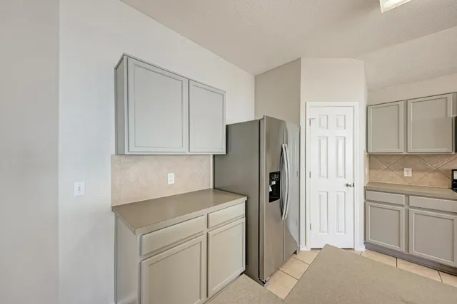 a kitchen with stainless steel appliances a stove a microwave and white cabinets