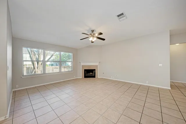 a view of a kitchen and an empty room with a fireplace