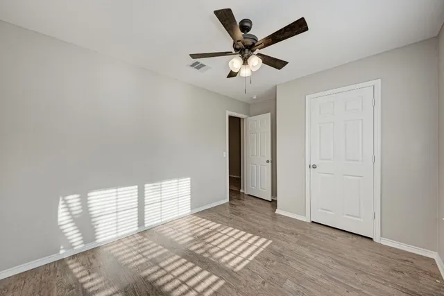 a view of a big room with windows and chandelier fan
