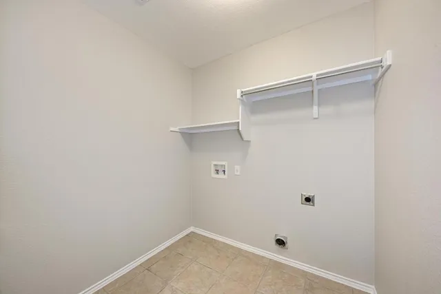 a view of an empty room with wooden floor and a ceiling fan