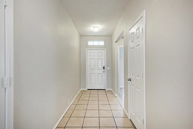 a view of a hallway with wooden floor and a bathroom